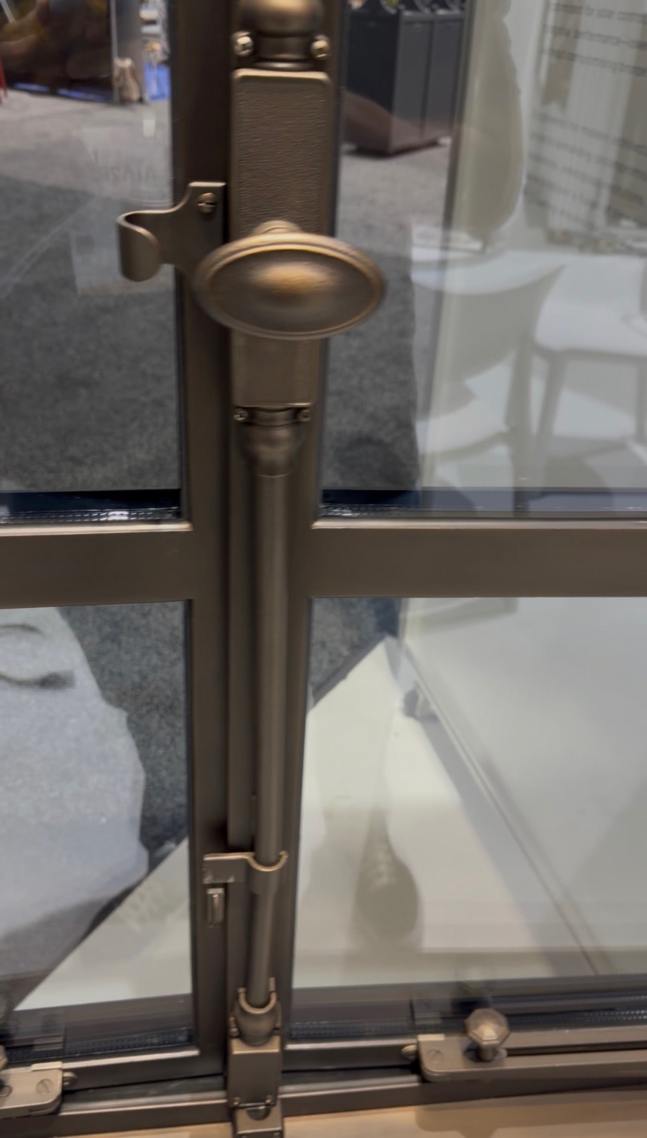 Close-up of a bronze steel window handle and locking hardware